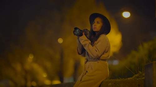 Woman Photographs Cityscape at Night