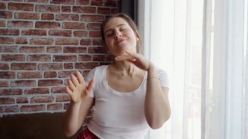Woman Dancing and Enjoying Music Near Window