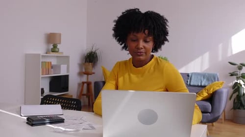 Focused Accountant Managing Invoices and Calculating Expenses at Home Office