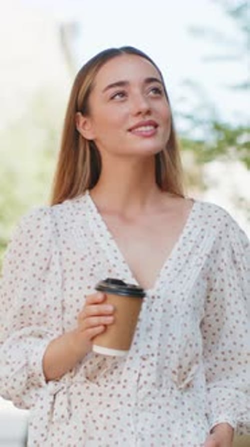 Happy Smiling Woman Walking on City Street Enjoying Morning Coffee Hot Drink Relaxing Taking a Break