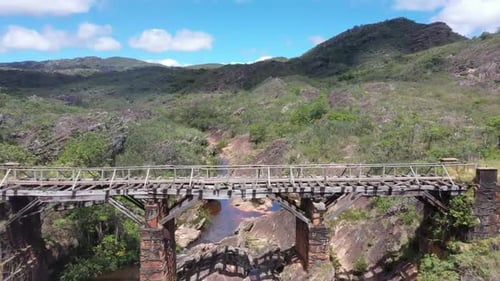 Luftbild einer alten Brücke mit einem darunter fließenden braunen Fluss. 4K-Videos. nähernde Aufnahme.
