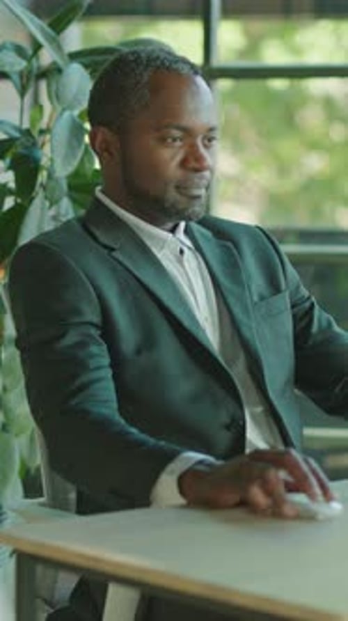 A Professional Man Diligently Working in a Modern Office to Achieve Goals and Drive Success