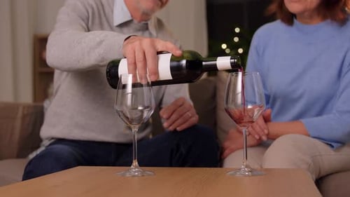 Mature Couple Pouring Red Wine at Home
