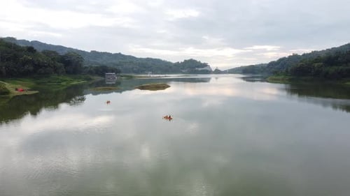 Asian People canoeing on a reservoir with a beautiful view
