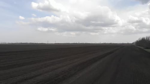Blue tractor working on the field in Odessa in Ukraine during planting sunflower