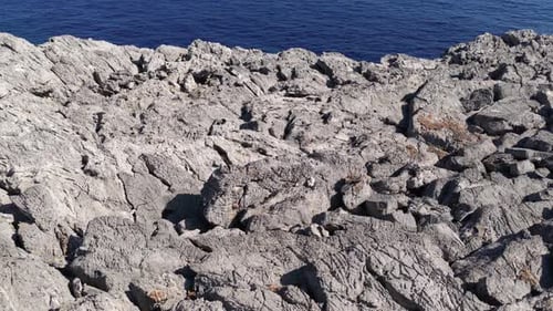 Rocky Cliffs Meet Blue Ocean on Sunny Day