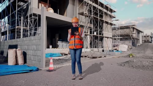 Full Body Of Asian Female Engineer Working On A Tablet At Building Site