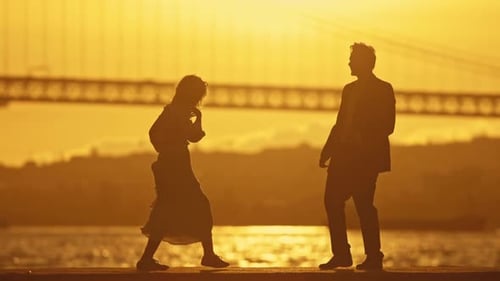 A Couple is Dancing on a Pier at Sunset