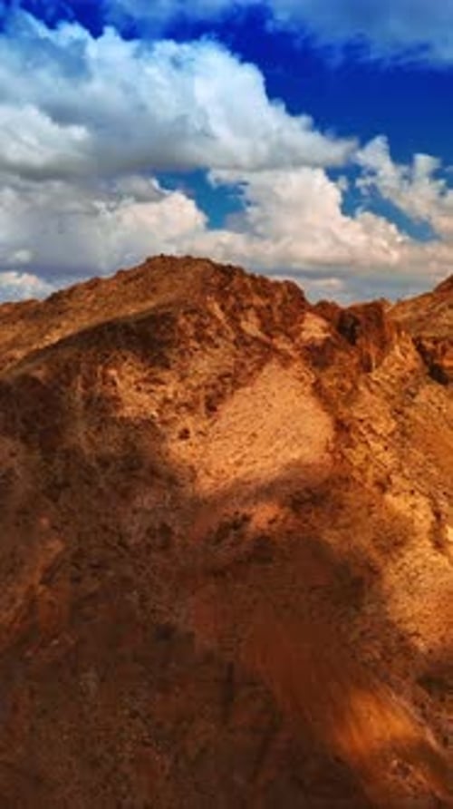 Brown rocks contrasting with azure skies in Mojave desert. Vertical video