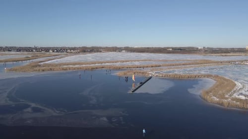 Aerial view of man ice sailing on frozen lake during winter