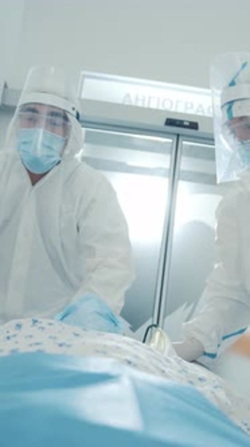 Emergency Department Workers in White Protective Body Suits Face Masks Delivering Injured Sick