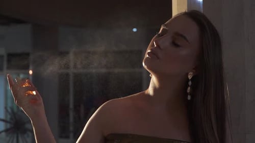 Woman Sprays Perfume on Herself in Urban Setting