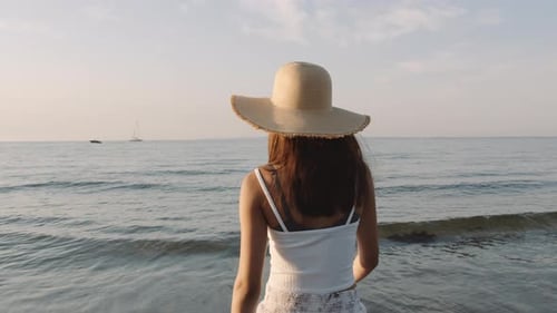 Foto média de uma garota no mar olhando para o sol