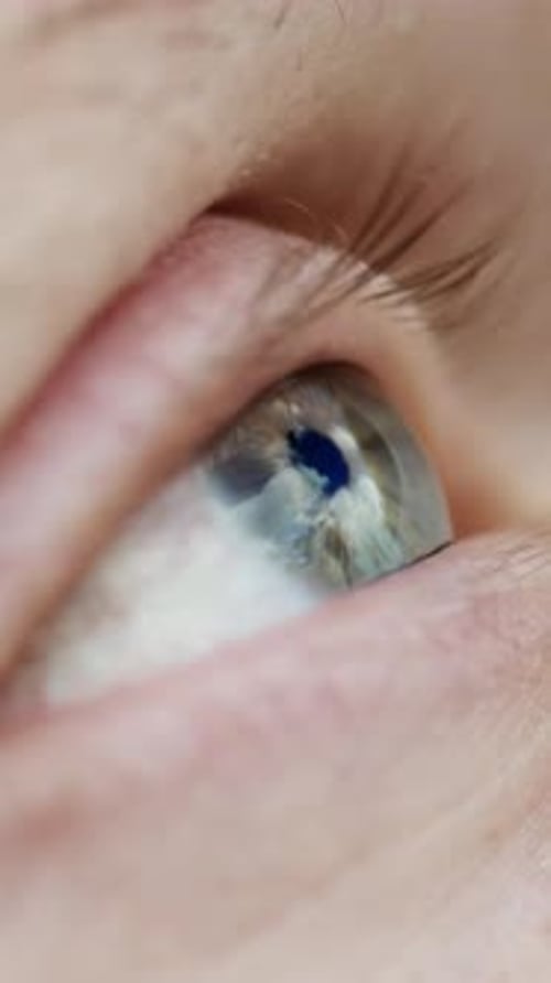 Menschliches Auge, das blauen Himmel und Wolken im Makrodetail reflektiert
