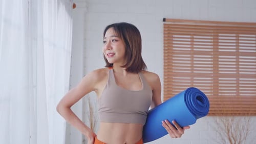 Portrait of Asian young sportswoman doing yoga pilates workout at home.