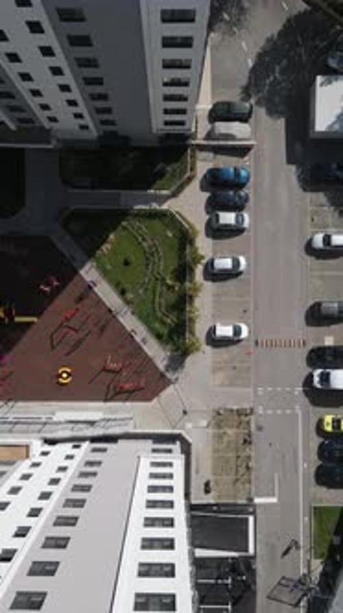 Vista desde arriba con un Zumbido de un patio residencial moderno con un área de juegos para niños, espacios verdes y un estacionamiento