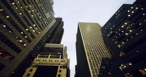 Vista hacia el cielo del horizonte urbano con edificios imponentes al anochecer