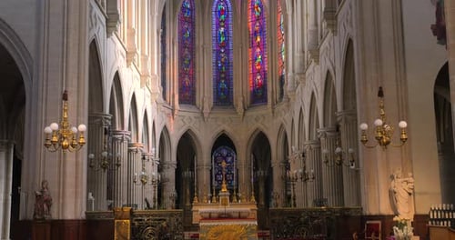 Tilt up shot of dimly lit alter in the interior of a roman catholic church of Saint-Germain-l'Auxerr