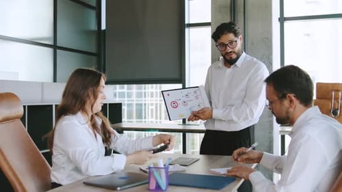 Three Professionals in a Contemporary Office Collaborate on Project Updates Brainstorming Solutions