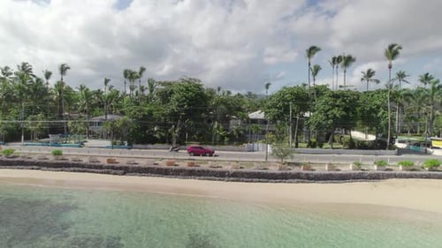 Aerial Tracking of Red Suv Car in Seaside Road of La Playa Town, Las Terrenas