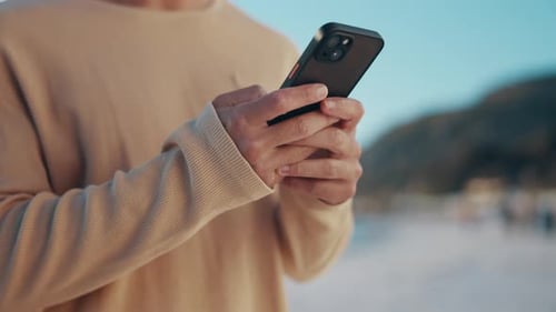 Man Using Mobile Phone on Beach During Day
