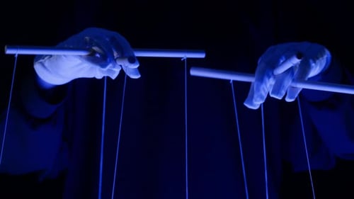 The Puppeteer Controls the Puppets in the Theater in Blue Neon Light Closeup Managing People at Work