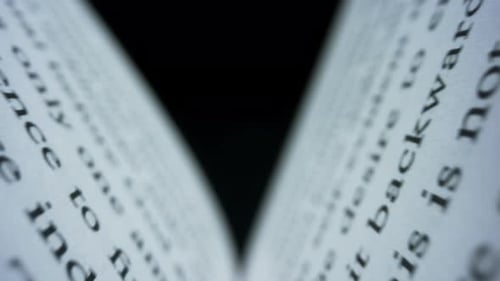 Camera Moving Between Paper Book Pages. Macro View Open Book Against Black