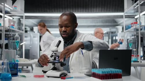 Scientist Works with Microscope in Bright Laboratory Setting