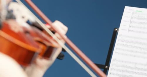 Woman Playing Violin Reading Sheet Music Close Up