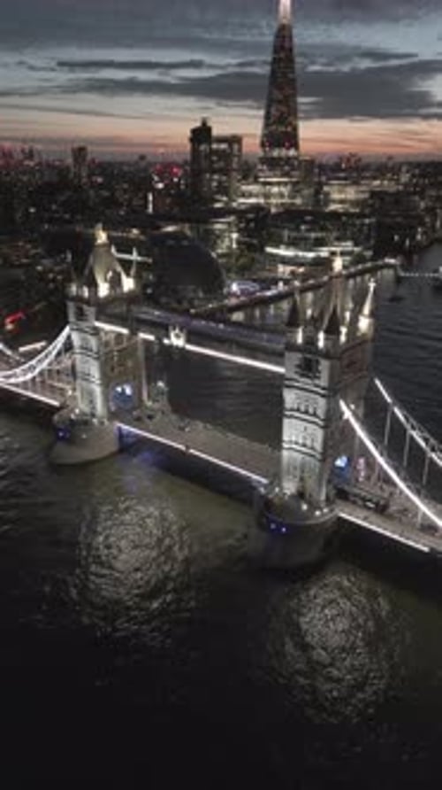 Aerial video of the city of London and the lighthouse bridge in London at night