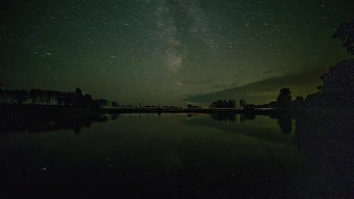 Dramatisch Zeitraffer des Sternenhimmels, der die Farben wechselt und sich auf dem Wasser spiegelt