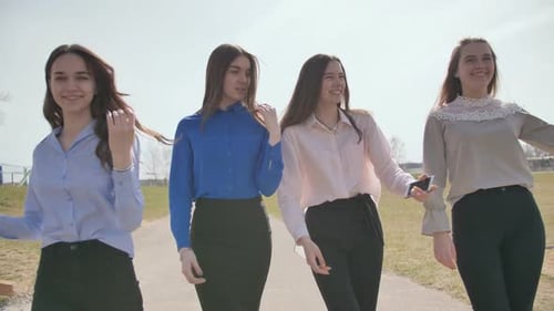 Cuatro chicas de diecisiete años caminan por la calle y posan