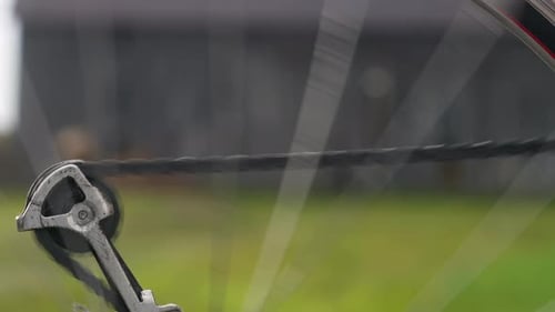 Bicycle Wheel Spinning With Chain In The Background. - close up