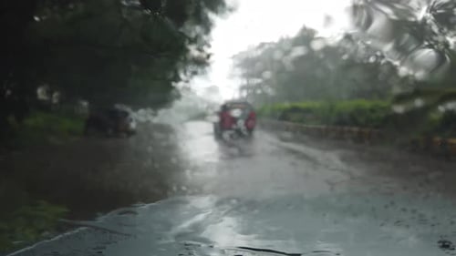 Lluvia cayendo sobre la vista del parabrisas del coche. Conduce el coche en una calle vacía, una fuerte lluvia, una tormenta, viaja