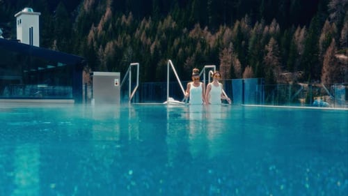 Femmes en maillot de bain blanc descendant dans la piscine