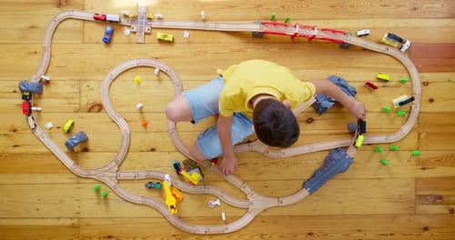Child Plays with Toy Train Set From Above