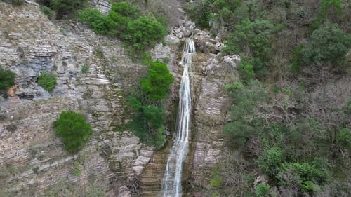 A Huge Long Waterfall Smoothly Flows Down a Picturesque Rock Aerial View