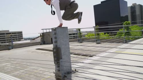 Businessman Jumping Over Parking Garage Barriers 20-25