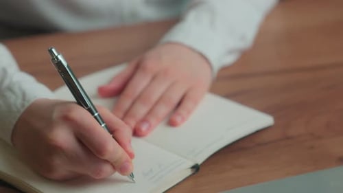 Thoughtful Woman Writing in Notebook in Office