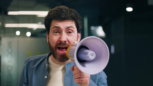 Raging Flushed Male Screaming with Megaphone and Waving Hand in Office