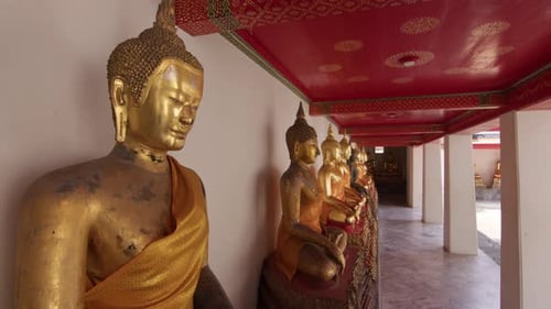 Row of Golden Buddha Statues in a Serene Temple Corridor
