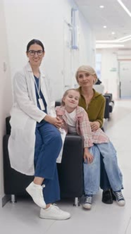 Mother and Daughter Posing next to Female Therapist in Clinic Hall