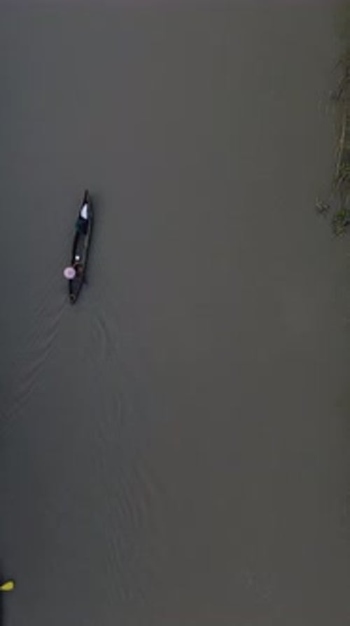 Vertical Drone Footage of Small Fishing Boats Floating on the River in the Forest