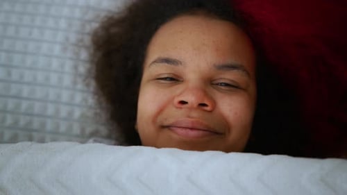 Woman Smiling Lying in Bed Relaxing