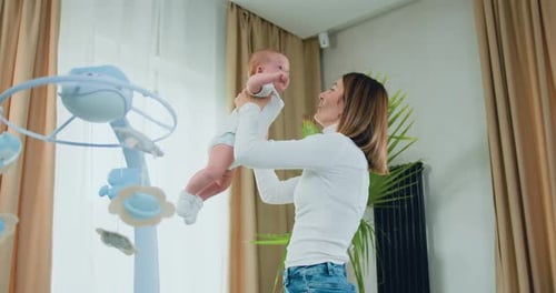 Mother Holds Her Baby up in the Air
