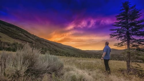 Motionless manlooking at a stunning view of a heavenly cloud formation. The man and landscape are mo