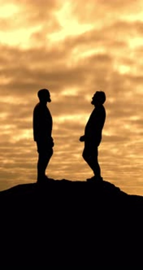 Silhouetted Men Standing on a Hill at Sunset