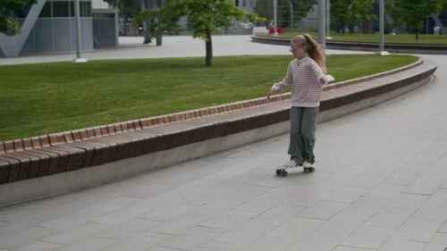 Active Girl on Skateboard Moving along Wooden Bench Surrounding Green Lawn