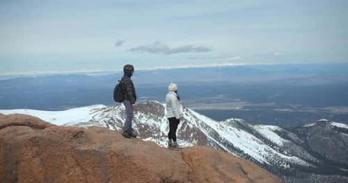 Couple Climbing Up Mountain, Hiking Rocky Mountains in Snow Adventure