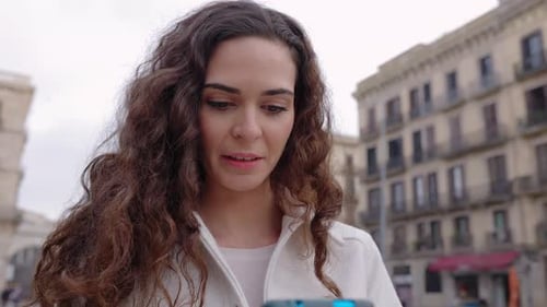 Happy Woman Using Mobile Phone at City Street